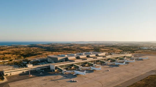 Vue aérienne de l'aéroport de Faro en haute saison avec des voyageurs sur le tarmac