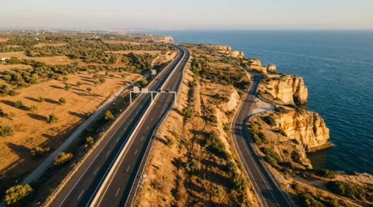 Vue panoramique montrant deux routes de l'Algarve - une autoroute moderne et une route côtière sinueuse