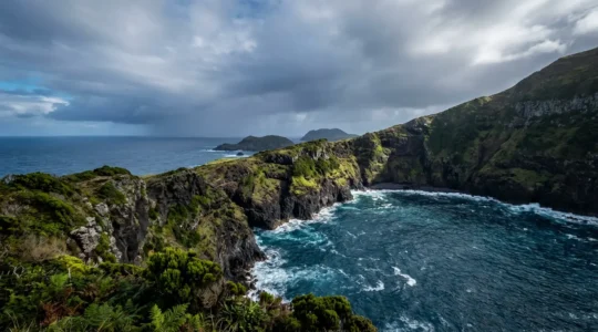 Paysage côtier des Açores avec falaises volcaniques et océan Atlantique sous un ciel changeant