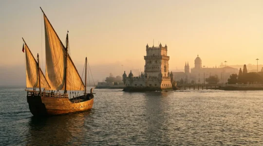 Vue atmosphérique de Belém au lever du soleil avec une caravelle historique voguant sur le Tage