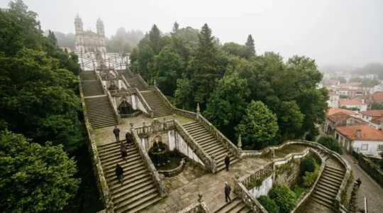 Vue plongeante sur les escaliers baroques en zigzag d'un sanctuaire portugais avec pèlerins en montée